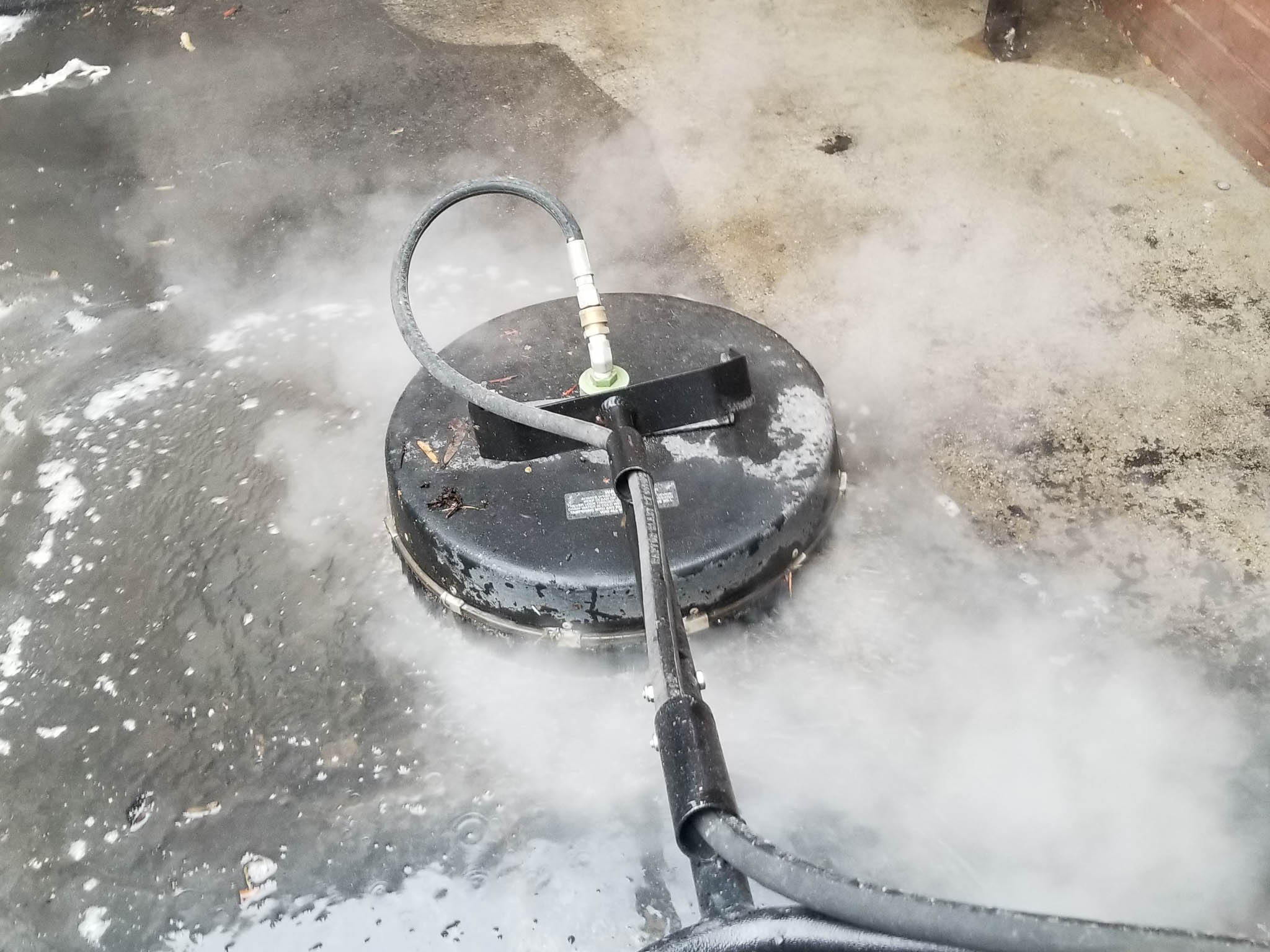 Rotary wash machine being used by Penson Pressure Washing team member to deep clean concrete walkway.