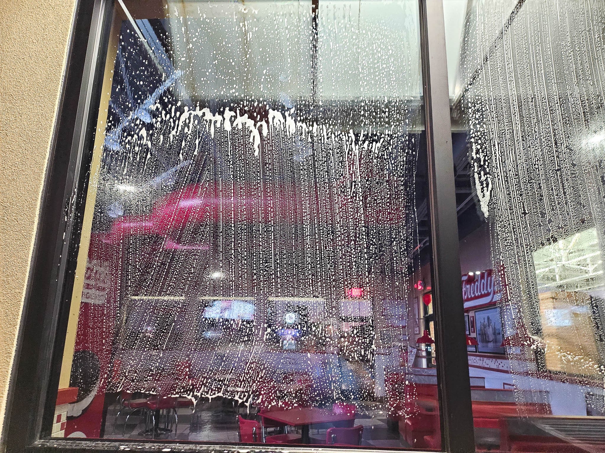 Suds on windows during soft wash process pictured for a restaurant franchise client to demonstrate Penson Pressure Washing team's range of soft wash services.